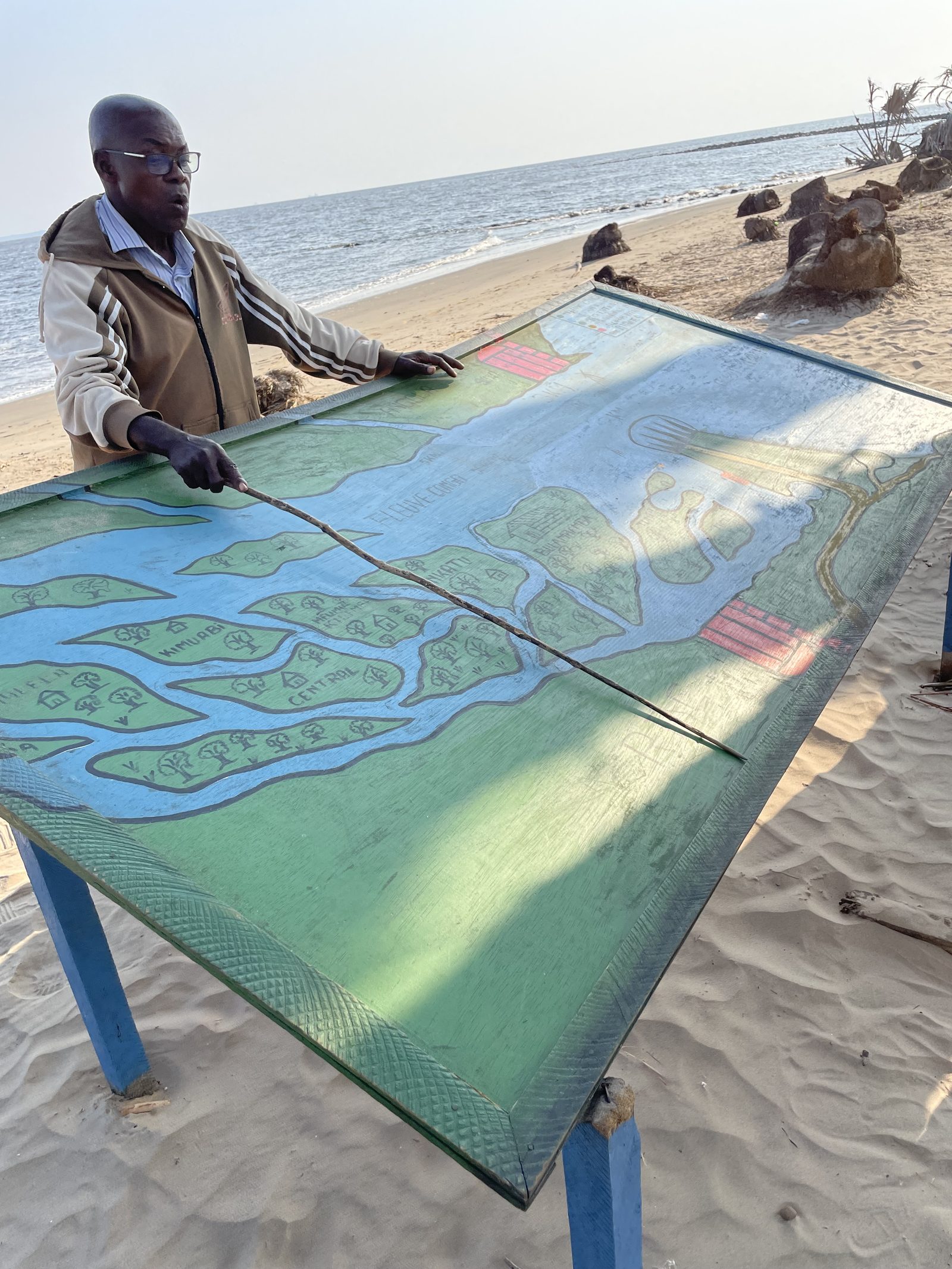 Un guide devant la carte de l'embouchure du fleuve, sur la plage de Muanda