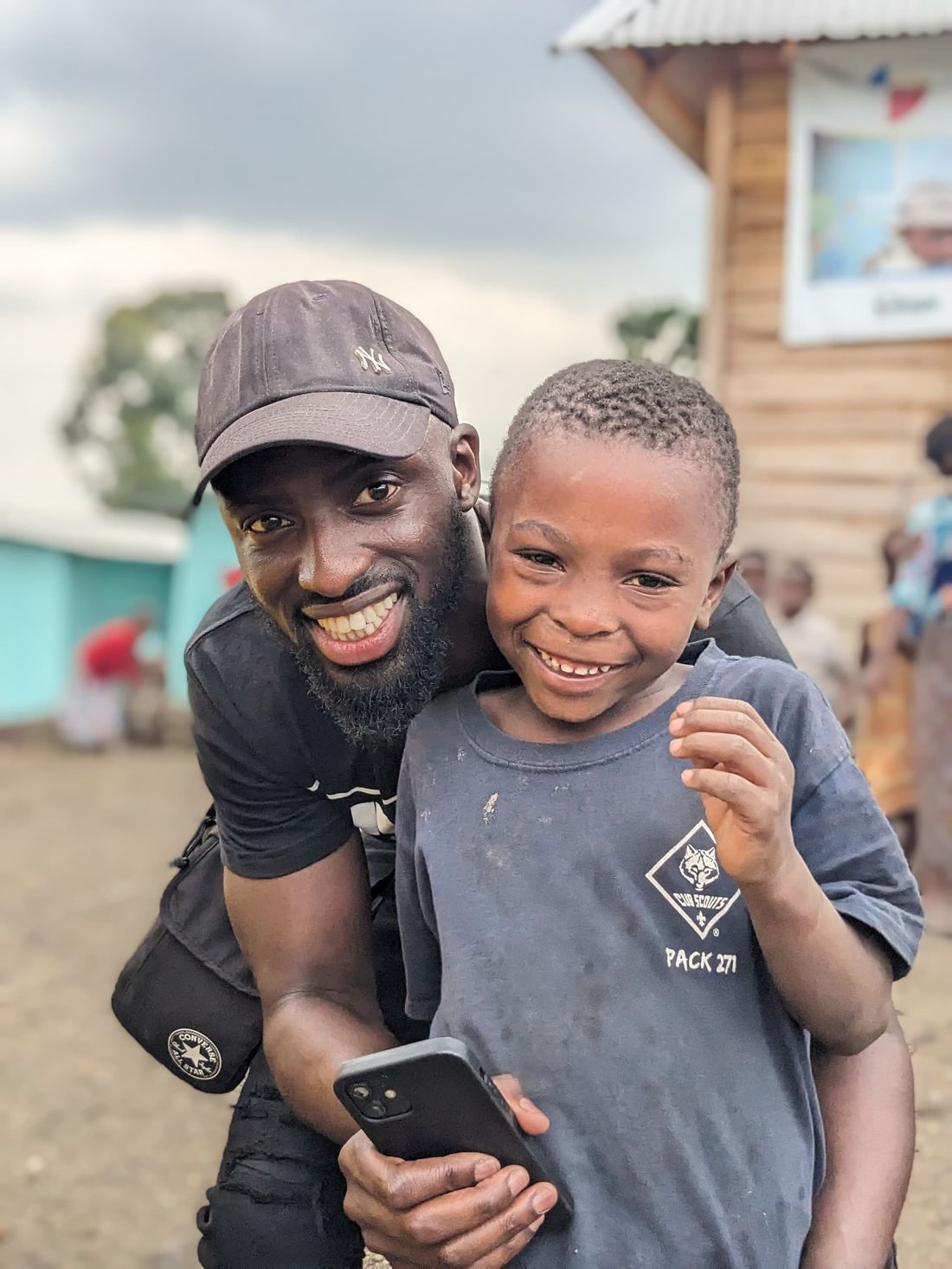 Le fondateur de Nzela en mission humanitaire, souriant aux côtés d'un enfant